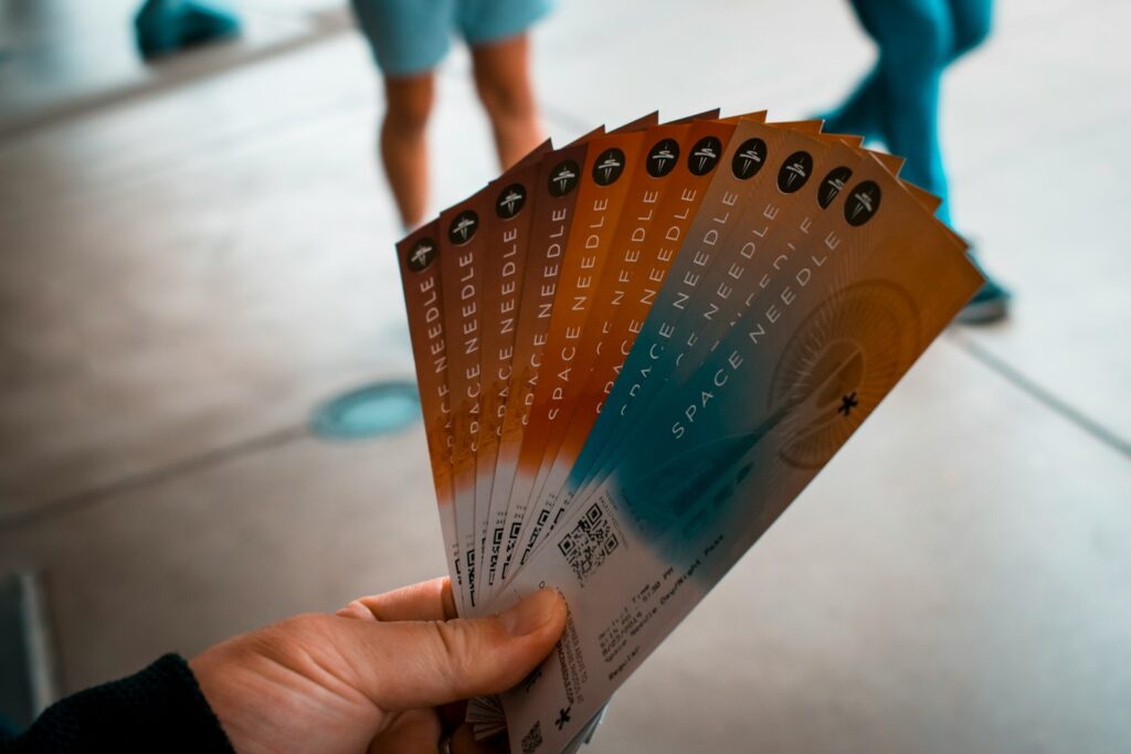 person holding brown, blue, and white tickets