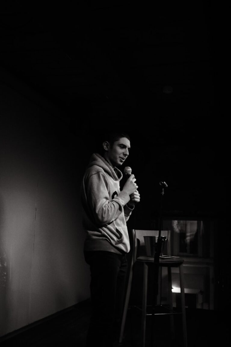 a man standing in a dark room holding a microphone